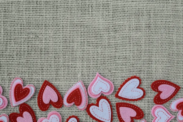 Çuval bezi arka plan üzerinde kırmızı Kalpler — Stok fotoğraf