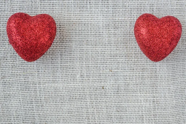 Красные сердца на фоне бурлапа — стоковое фото