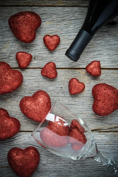 Copo de vinho e vinho com corações vermelhos no Dia dos Namorados — Fotografia de Stock