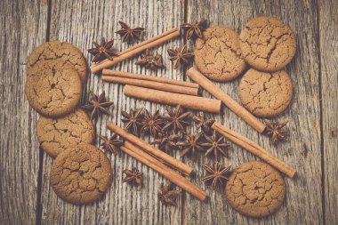 Cinnamon sticks, star anise and gingersnap cookies on rustic woo clipart