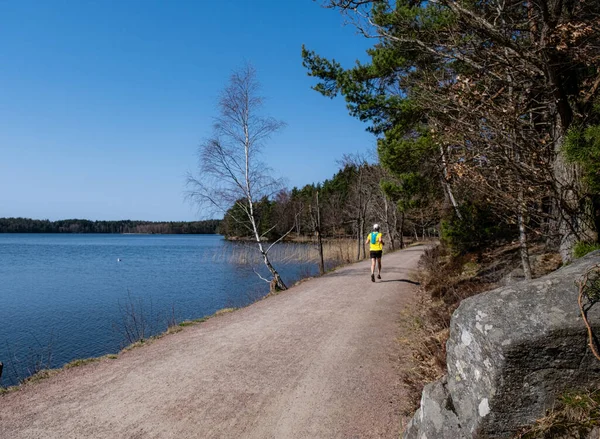 在瑞典 男性健身爱好者于早春在湖边和林地边慢跑 — 图库照片