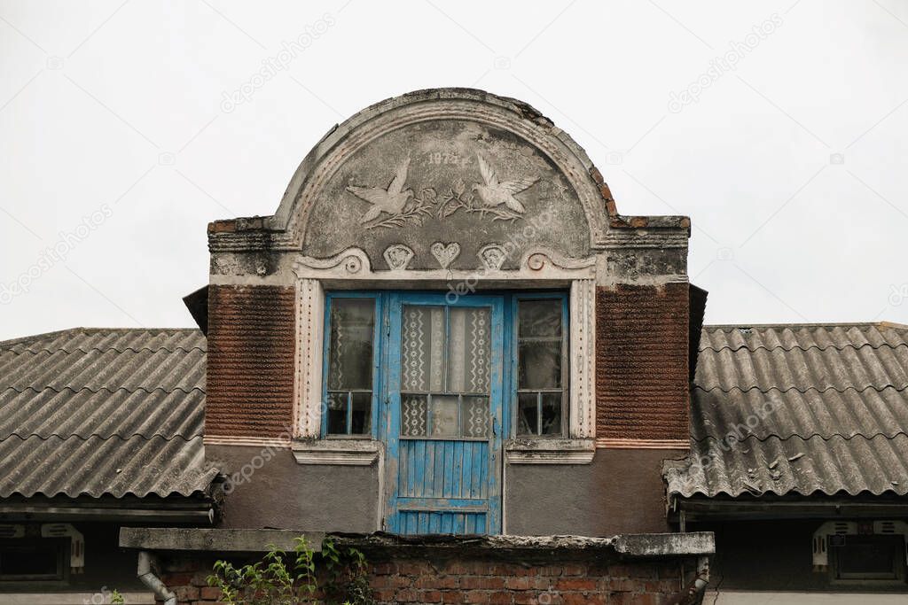 Mezzanine in a neglected brick house. Traditional western Ukrainian architectural detail with the inscription of the year of construction 1975. Copy space.