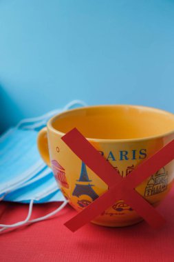 Seyahat yasağı konsepti. Coronavirus hastalığı koruması. Paris yazılı bir bardakta içki yasağı tabelası. Toplu bardak üretimi. Dikey resim.