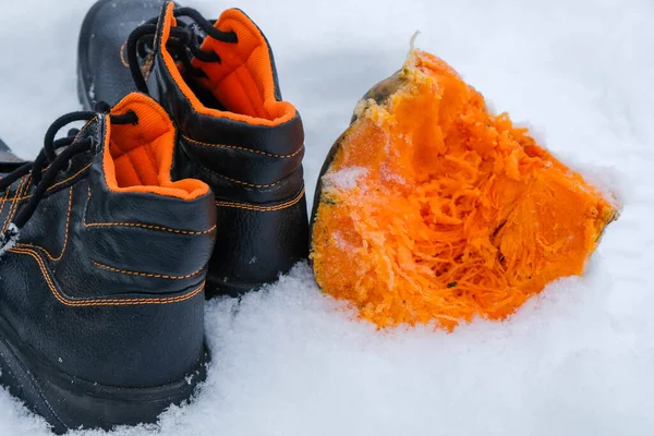 New work shoes with orange reflective lining. Snow background.