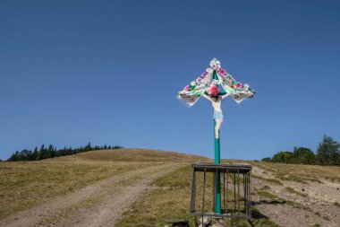 İsa Mesih 'in bir dağ çayırında çarmıha gerilmesi. Güneşli bir sonbahar günü. Karpatlar, Ukrayna. Boşluğu kopyala.