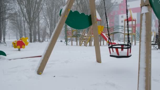 Prázdná Houpačka Parku Během Sněžení Dětské Dřevěné Hřiště Pozadí Růžovo — Stock video