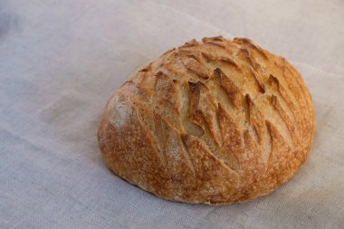 Tuvalin üzerinde yuvarlak taze ekmek. Ukrayna zanaat ekmeği. Boşluğu kopyala.