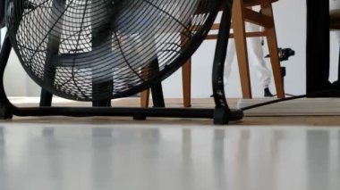 Havalandırma fanı fotoğraf stüdyosunun arka planında çalışıyor. Egzersiz yapan bir kızın bulanık görüntüsü.