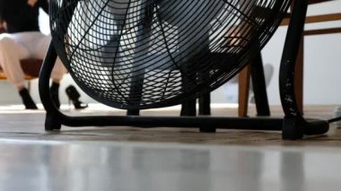 Havalandırma fanı fotoğraf stüdyosunun arka planında çalışıyor. Fotoğraf çekimine hazırlanan bir kızın bulanık görüntüsü.