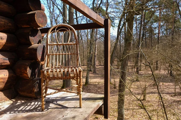 Silla Mimbre Vacía Porche Una Cabaña Madera Sobre Fondo Forestal —  Fotos de Stock