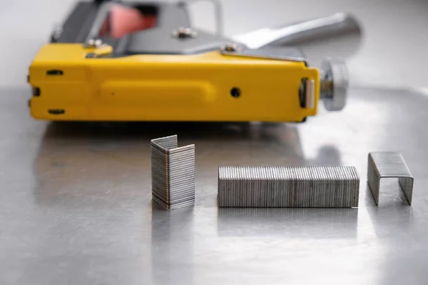 Metal staples on the background staple gun. Gray steel surface. Many different applications. Copy space.
