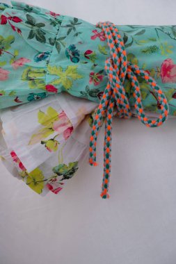 Parlak bir iple bağlanmış iki renkli yaz elbisesi. Dikey resim.