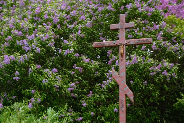 Houten Kruis Met Een Kruisbeeld Een Lila Bloem Achtergrond — Stockfoto