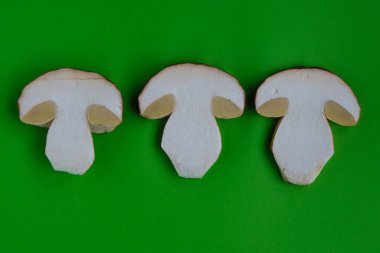 Yeşil kağıt üzerinde üç boletus kesiti. Dilimlenmiş mantar. Üst Manzara. Boşluğu kopyala.