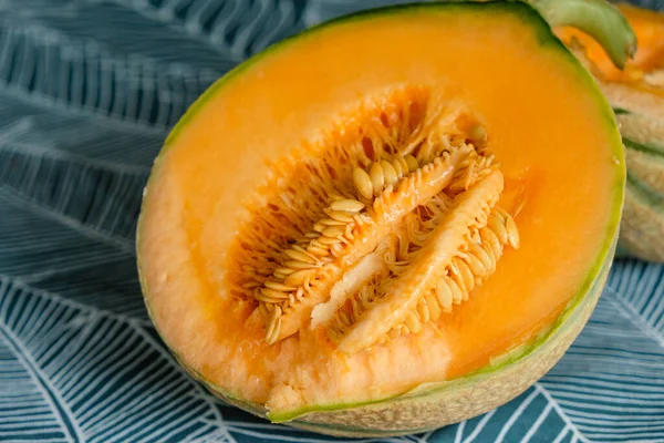 Sliced melon with juicy pulp and ripe seeds. Harvesting melon seeds. Close up.