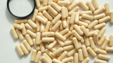 Parlak Güneş Işığında Beyaz Arkaplan 'daki Biyolojik Aktif İlaveler. Hap kapağı. Döndürme. Alternatif İlaç Tabletlerinin Üretimi, Tüketimi ve Depolaması.