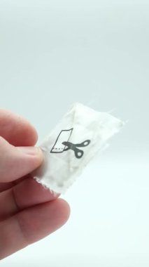 Elinde makas sembolü olan manyetik etiket veya kıyafet güvenlik etiketi.