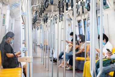 Asya çevresi yolcuları gökyüzü treninin içinde, herkesin yüzünde maskeler var..