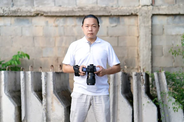 Asian Man Serious Looks Camera While Holds Mirrorless Camera Medium — Stock Photo, Image