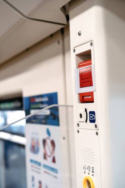 Gökyüzü treninin içindeki kırmızı acil durum kapısı açma düğmesi kapının yanına kurulmuş..