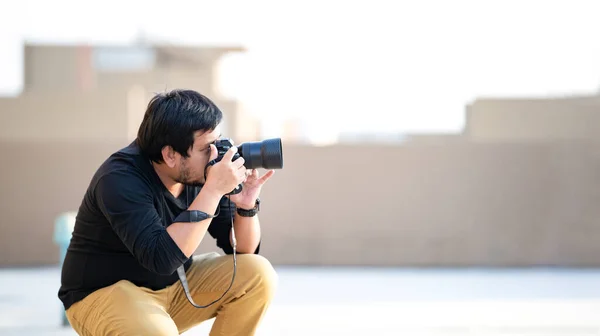 아시아인 프로페셔널 카메라맨은 카메라 뷰파인더를 찾아서 경기장에서 사진을 초점을 맞춘다 — 스톡 사진