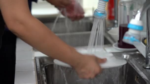 アジアの女性は流しで白い皿を洗っていた — ストック動画
