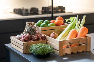 Sebzeli havuç, patates, limon, domates, soğan, sarımsak paketi ve tahta kutuda mikro bitki. Stüdyo ışığında çekilmiş..