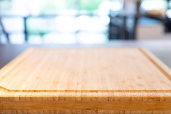 wooden cutting board base on the table with perspective wood over blur light bokeh background for package and product content mockup banner and advertisment template.