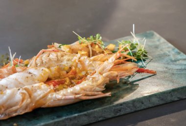 Istakoz Pad Thai, stüdyo ışıklarındaki dikdörtgen tabakta kızarmış erişte, tofu ve diğer malzemelerle servis yapmaya hazır..