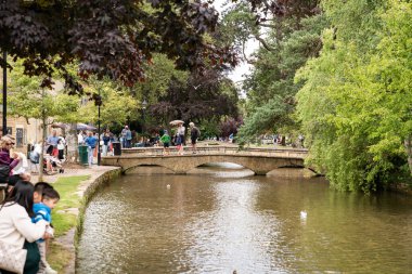 Bourton-on-the-Water, Birleşik Krallık, 12 Temmuz 2023, Yeşil Ağaçların arasından Kanal Akıyor, Cotswolds 'un Kalbinde Barışçıl Bir Doğa ve Yansıma Anı.