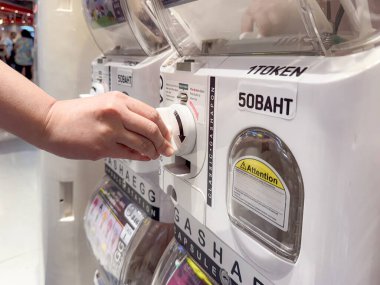 Bangkok, Tayland, 4 Ekim 2025, Bir İnsan Kapsül Oyuncak Otomatının Sapını Döndürür. Parlak bir Pazartesi sabahı, Rastgele Bir Sürprizin Neşeli Beklentisini Yakalamak.