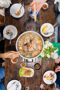 Dilimlenmiş et ve sebzeler et suyu ve buharla dolu metal bir ızgarada pişirilirken merkez de eti kızartır..