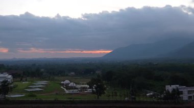 Ufuk boyunca uzanan geniş dağ sıraları Nakhon Ratchasima 'daki Khao Yai' de yumuşak bir akşam gökyüzünün altında, yumuşak ışık ve katmanlı bulutlar sakin bir doğal atmosfer yaratıyor..