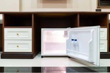 Buzdolabı. Delux Otel 'de masanın altında yanında ahşap bir masa var..