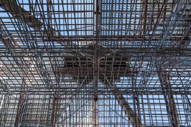 İnşaat alanında inşaat halindeki devasa çelik çatı iskeleti yapısının yükseliş açısı fotoğraf çekimi.