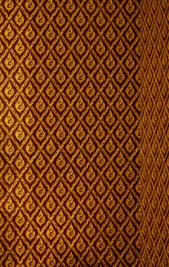 Kırmızı arka planda geleneksel Tayland altın deseni. Karmaşık dekoratif tasarımlı. Lüks dekorasyon, kültürel markalaşma ve kaliteli arka plan kullanımı için uygun.