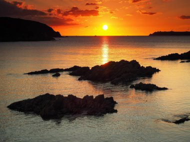 Batı Angle Körfezi ve balıkçı teknesi Pembrokeshire, Galler üzerinde çarpıcı turuncu gün batımı