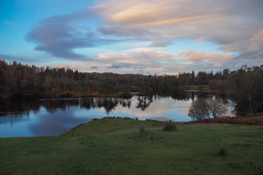 Gün batımında Tarn Hows 'a bak Suya yansıyan bulutlarla, Göl Bölgesi
