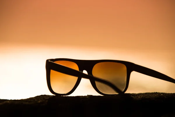 Солнечные очки на закате — стоковое фото