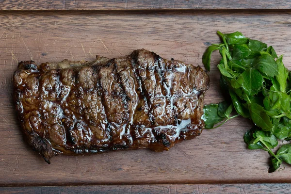 Bife grelhado em tábua de madeira — Fotografia de Stock