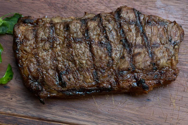 Bife grelhado em tábua de madeira — Fotografia de Stock