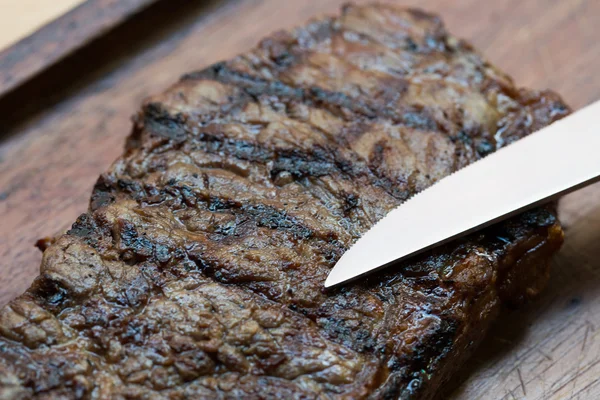 Bife grelhado em tábua de madeira — Fotografia de Stock