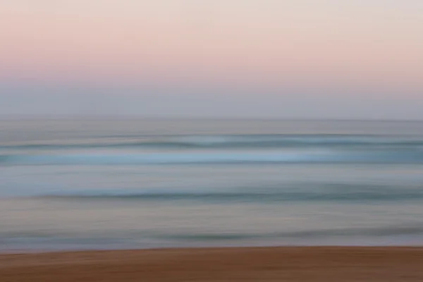 Abstract sunrise ocean background with blurred panning motion — Stock Photo, Image