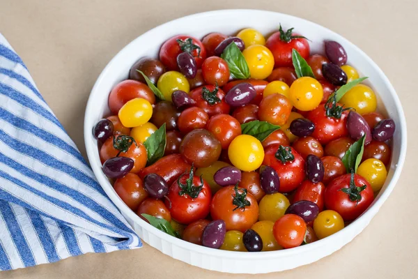 Ensalada de tomate cherry con albahaca y aceitunas Imagen De Stock