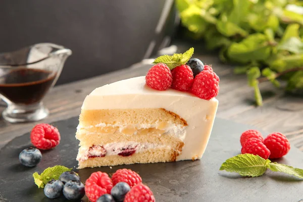 Ein Stück leckerer Kuchen mit Beeren und Minze — Stockfoto