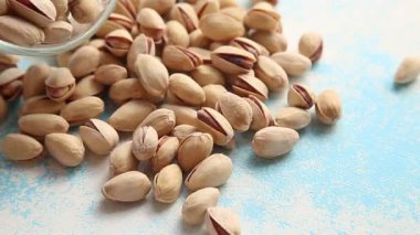 Fıstıklar mavi arka fona düşüyor.