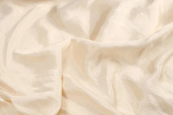 Soft smooth beige silk fabric background. Fabric texture.