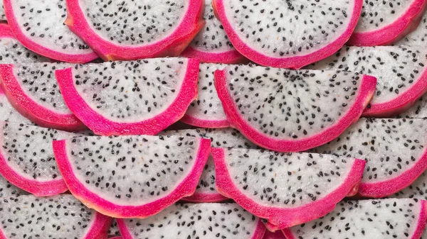 stock image Sweet tasty dragon fruit or pitaya slices as a background.