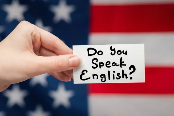 Do you speak English text on a card. American flag background.