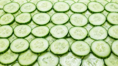 Arka plan olarak taze yeşil salatalık dilimleri. Üst görünüm. 